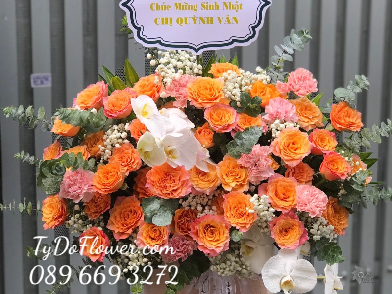 G0623756 GIỎ HOA CHÚC MỪNG SINH NHẬT thiết kế hoa hồng Cam Spirit, Lan Hồ Điệp trắng, cẩm chướng cam, baby trắng, lá bạc