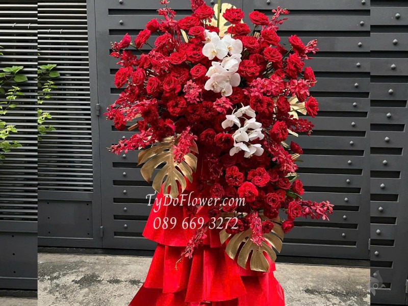 KCM0625491 KỆ HOA CHÚC MỪNG KHAI TRƯƠNG Thiết kế Hoa Hồng Đỏ Ohara Red Roses, Lan Đỏ Mokara, Lan Hồ Điệp, Lá Trầu Bà Nam Mỹ