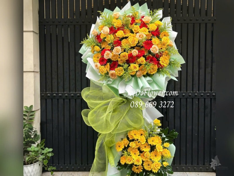 KCM1025853 KỆ HOA CHÚC MỪNG HỘI NGHỊ Thiết kế hoa hồng vàng cam, đồng tiền đỏ vàng trên nền giấy mỹ thuật cao cấp