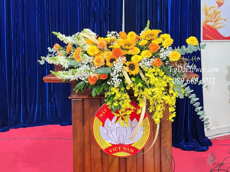 L1025861 HOA TRANG TRÍ BỤC PHÁT BIỂU Thiết kế Hoa hồng cam Spirit, hướng dương, đồng tiền, lan vũ nữ