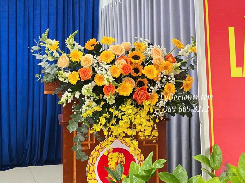 L1025863 HOA TRANG TRÍ BỤC PHÁT BIỂU Thiết kế Hoa hồng cam Spirit, hướng dương, đồng tiền, lan vũ nữ