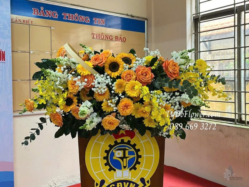 L1025865 HOA TRANG TRÍ BỤC PHÁT BIỂU Thiết kế Hoa hồng cam Spirit, hướng dương, đồng tiền, lan vũ nữ