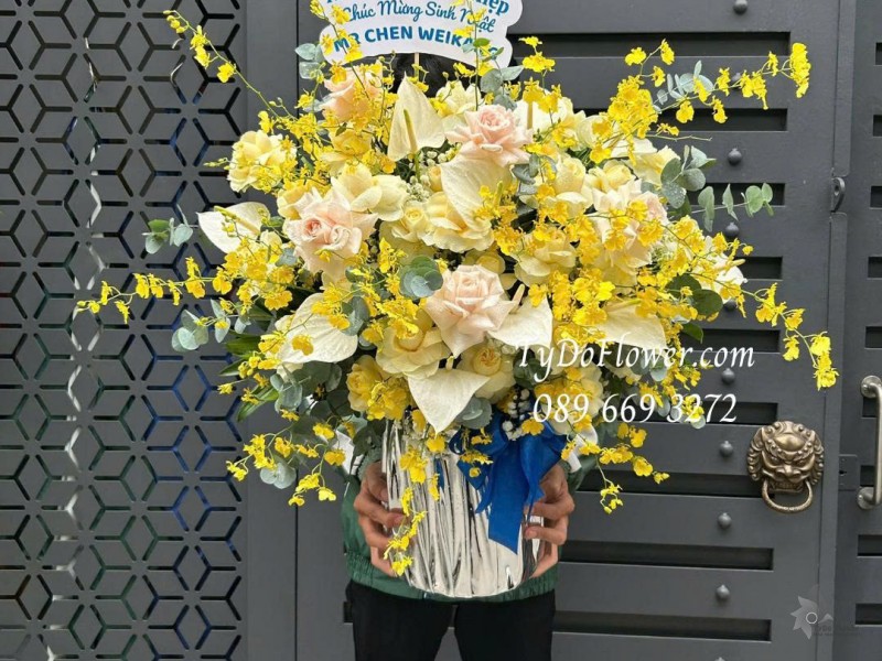 G0226151 GIỎ HOA CHÚC MỪNG SINH NHẬT Thiết kế tông màu vàng, hoa lan vũ nữ, lá môn trắng, hoa hồng vàng victor