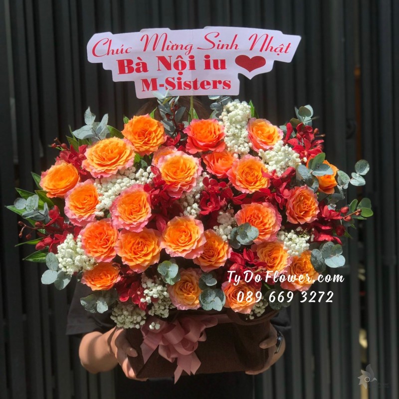 G09231033 GIỎ HOA CHÚC MỪNG SINH NHẬT BÀ thiết kế Hoa Hồng Cam Spirit Roses, Hoa Lan Mokara Đỏ mix Baby Trắng, Lá Bạc