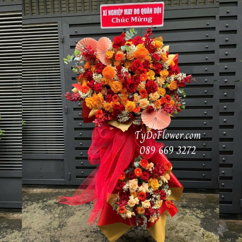 KCM0725503 KỆ HOA CHÚC MỪNG Thiết kế gam màu đỏ cam, chủ đạo hoa hồng đỏ, hoa hồng cam party, đồng tiền