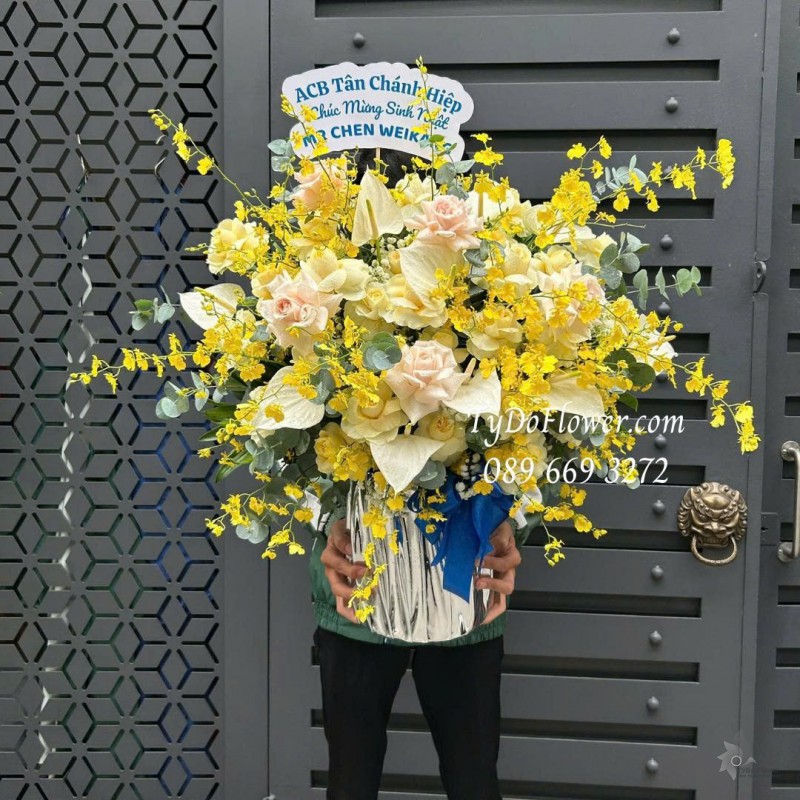 G0226151 GIỎ HOA CHÚC MỪNG SINH NHẬT Thiết kế tông màu vàng, hoa lan vũ nữ, lá môn trắng, hoa hồng vàng victor