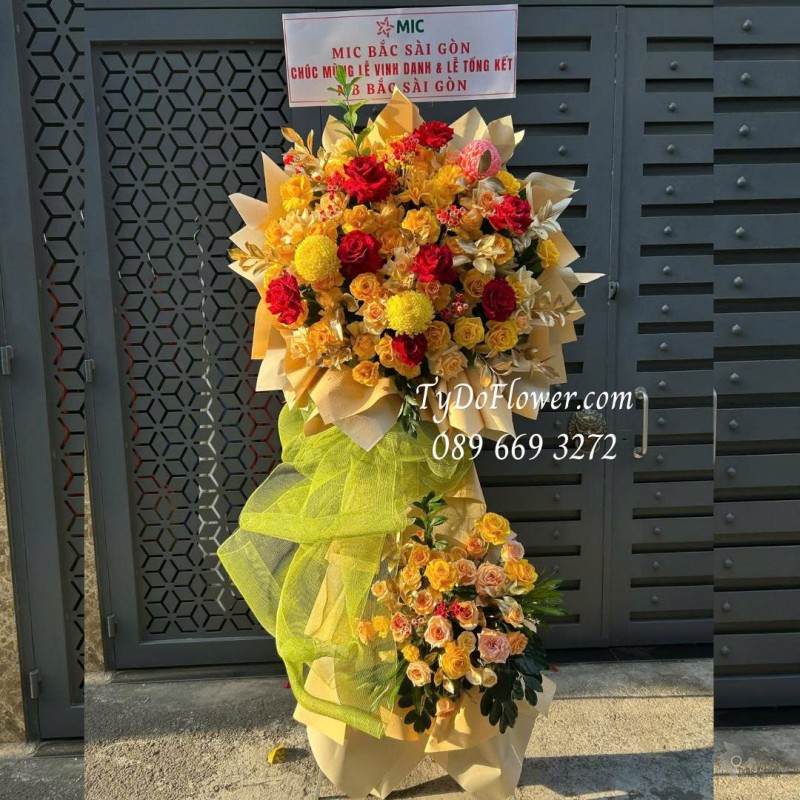 KCM0226177 KỆ HOA 02 TẦNG CHÚC MỪNG Thiết kế tông màu đỏ vàng cam, chủ đạo hoa hồng, cúc mẫu đơn trên nền giấy mỹ thuật cao cấp