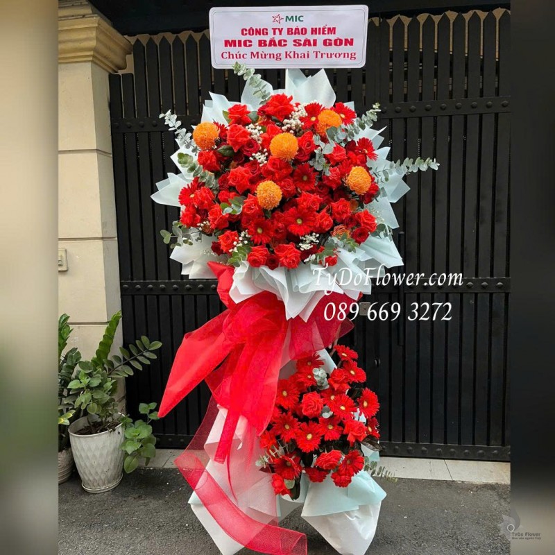 KCM0226178 KỆ HOA 02 TẦNG CHÚC MỪNG KHAI TRƯƠNG Thiết kế tông màu đỏ cam, chủ đạo hoa hồng, đồng tiền, cúc mẫu đơn trên nền giấy mỹ thuật cao cấp