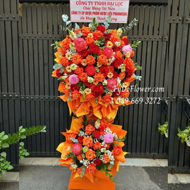 KCM0226179 KỆ HOA 02 TẦNG CHÚC MỪNG TẤT NIÊN Thiết kế tông màu đỏ cam, chủ đạo hoa hồng, cúc mẫu đơn trên nền giấy mỹ thuật cao cấp